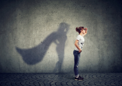 Woman whose shadow is wearing a cape